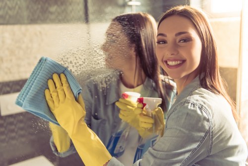 Cleaner deep scrubbing a hard floor in a busy facility