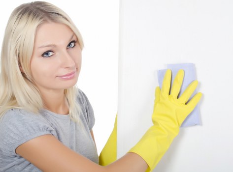 Cleaner wearing PPE while working safely in a property