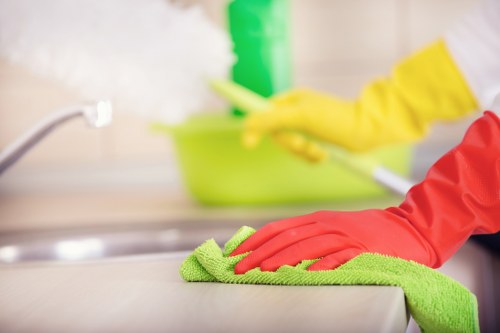 Cleaner in cleaners mopping a bright kitchen floor with care